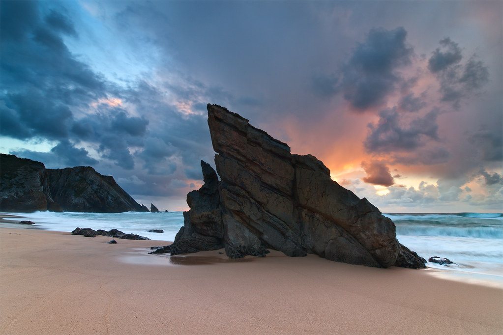 Adraga beach at sunset with rock formations and Atlantic waves