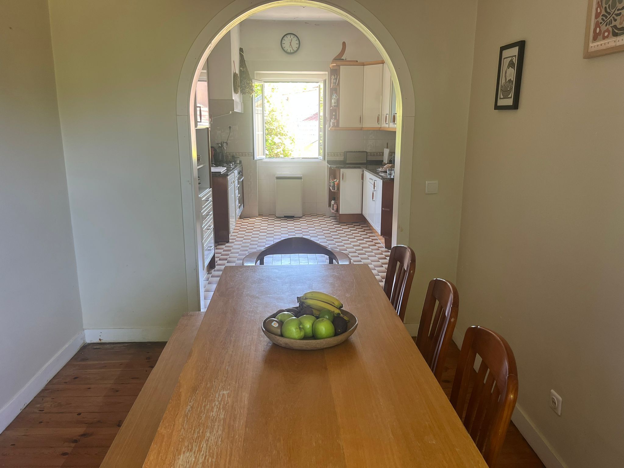 Dining table looking through an archway into the kitchen