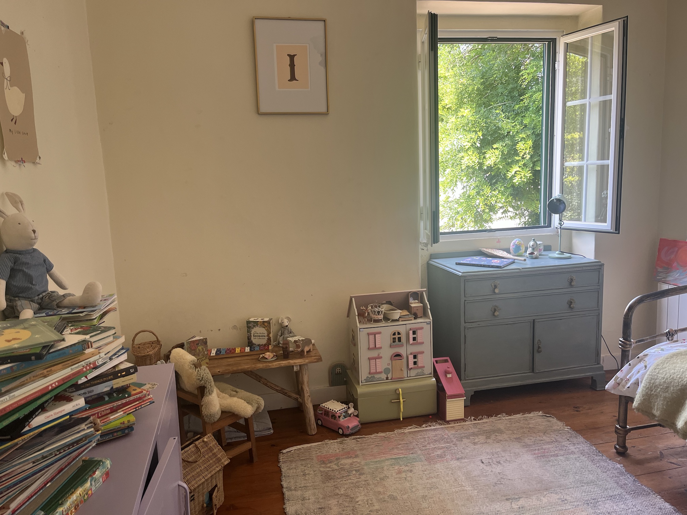 Kids' bedroom with wooden floors, open window and garden view